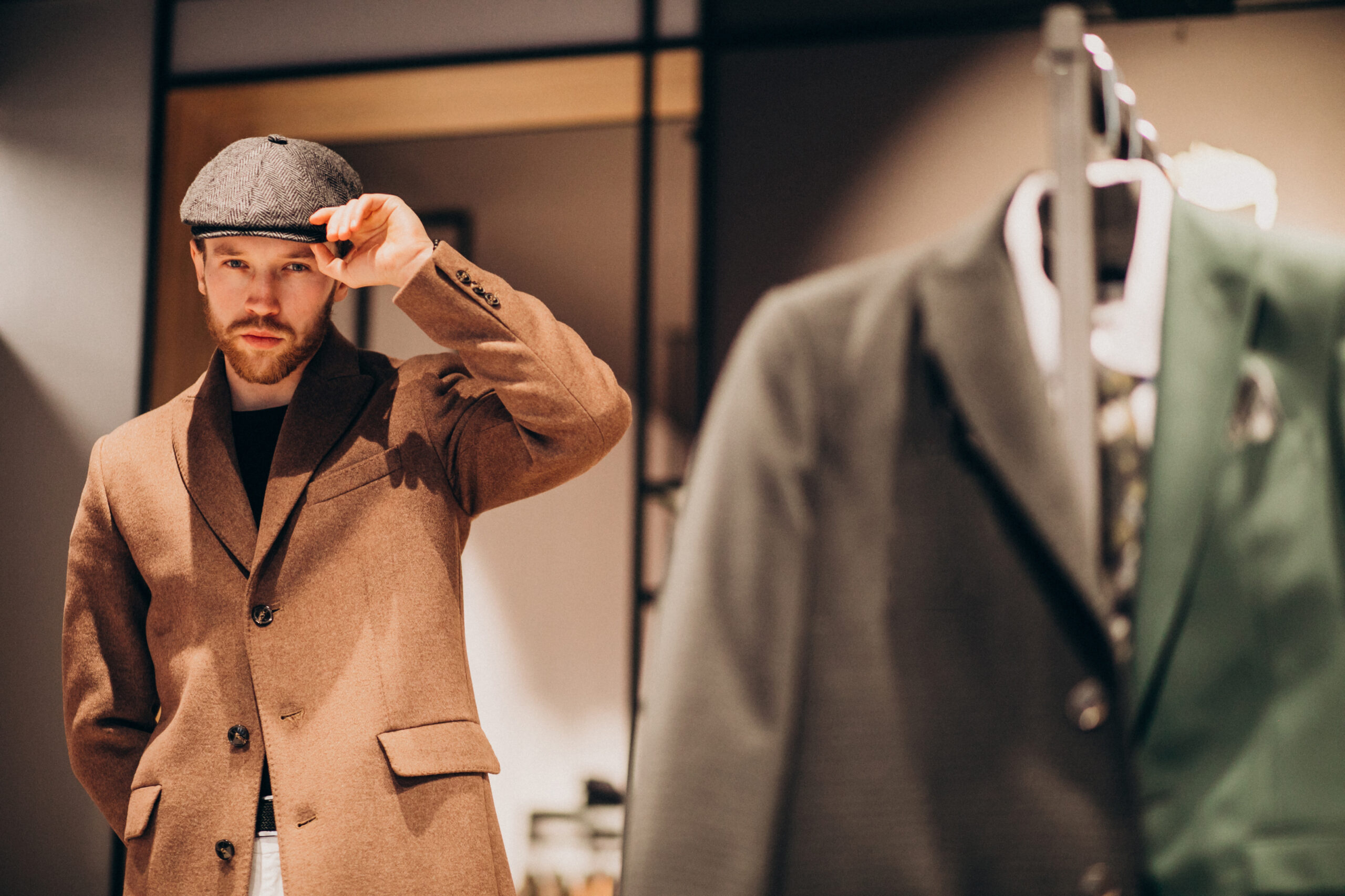 Young handsome man choosing hat at the shop